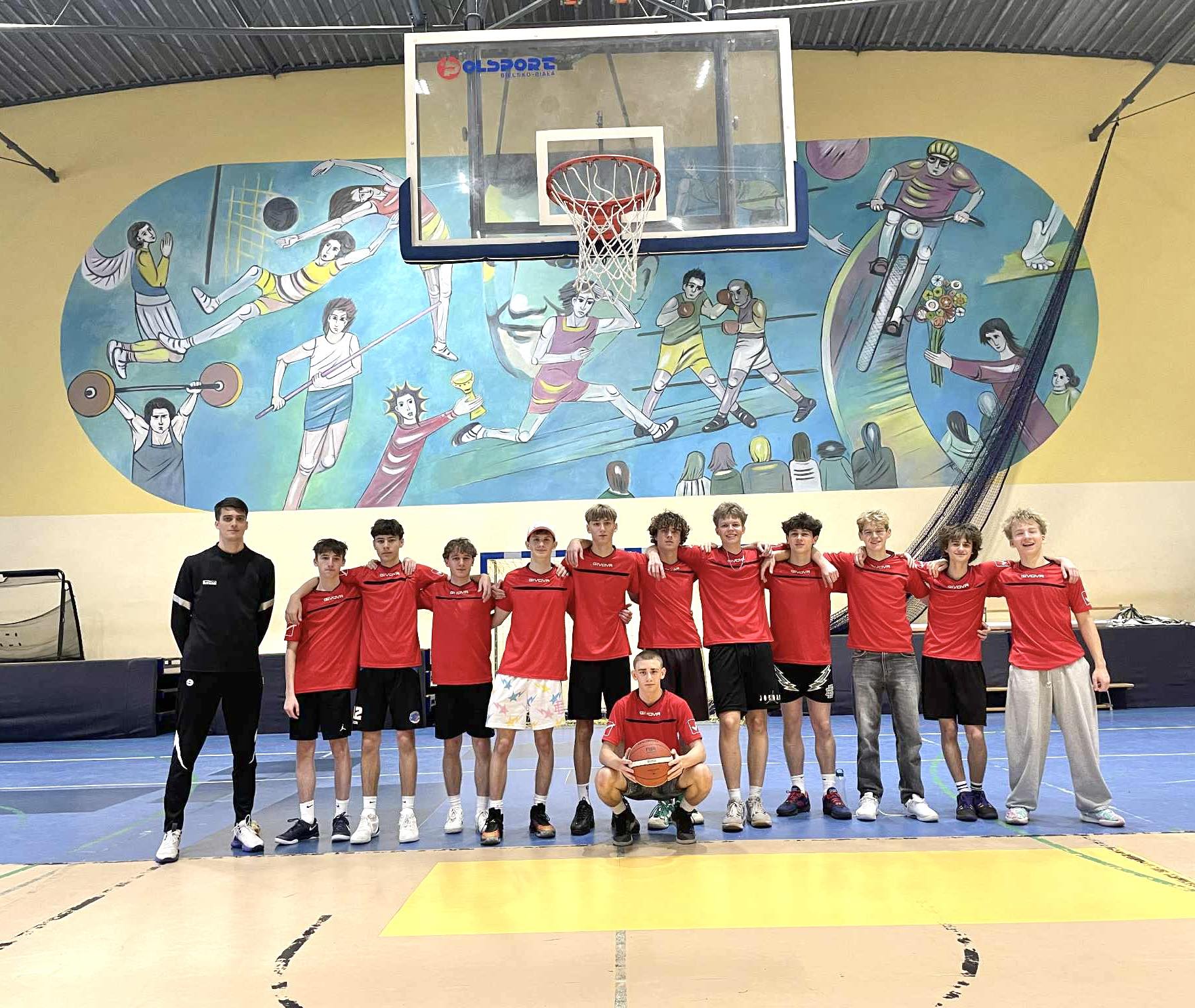 Nasz drużyna koszykarska pozuje ze swoim nauczycielem wf-u.