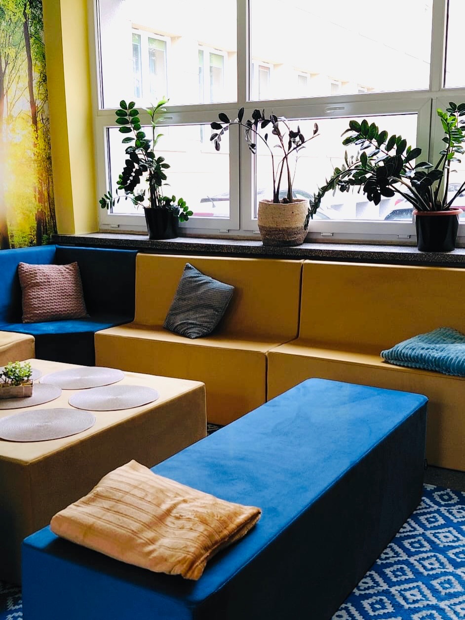 Kolorowe kanapy i poduszki, fototapeta z widokiem na las