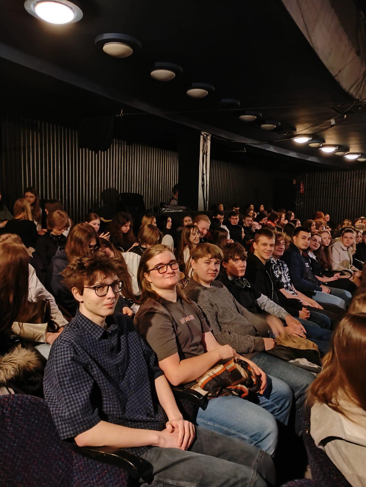 Uczniowie siedzący na widowni