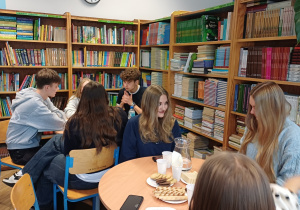 Uczniowie siedzący w bibliotece